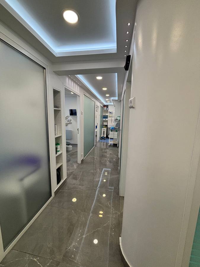 Couloir desservant les salles de soins, portes vitrées dépolies et niches de rangement