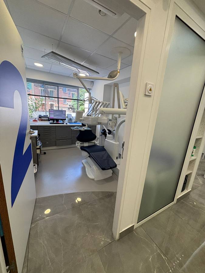 Salle de soins dentaires équipée, sol souple médical et mobilier gris