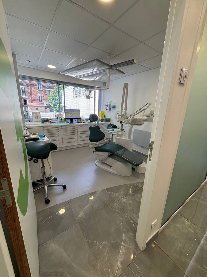 Seconde salle de soins dentaires avec mobilier blanc et large baie vitrée