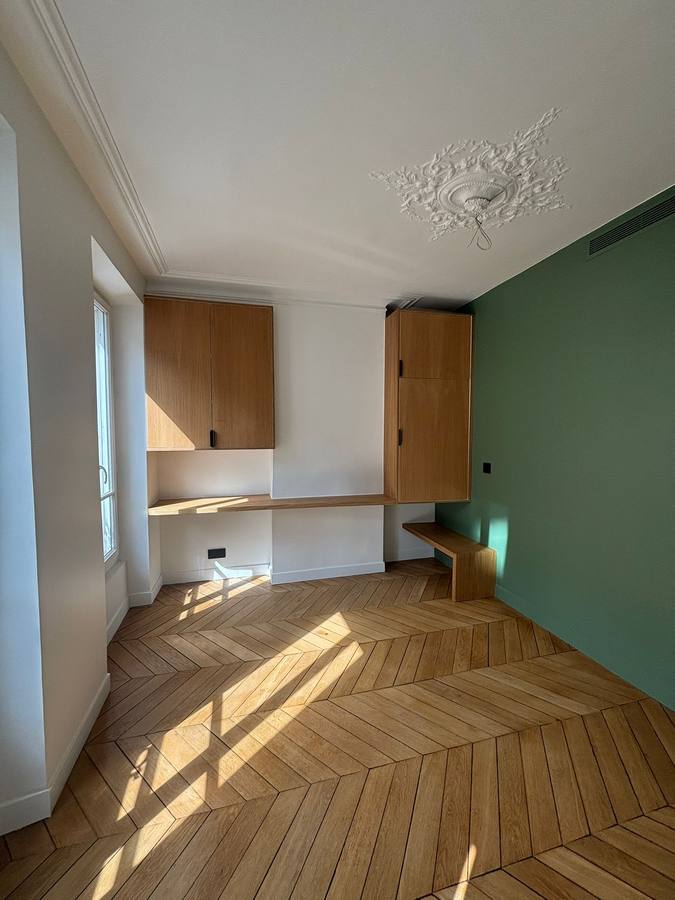 Chambre avec bureau et placards en chêne sur mesure, mur vert et parquet chevron